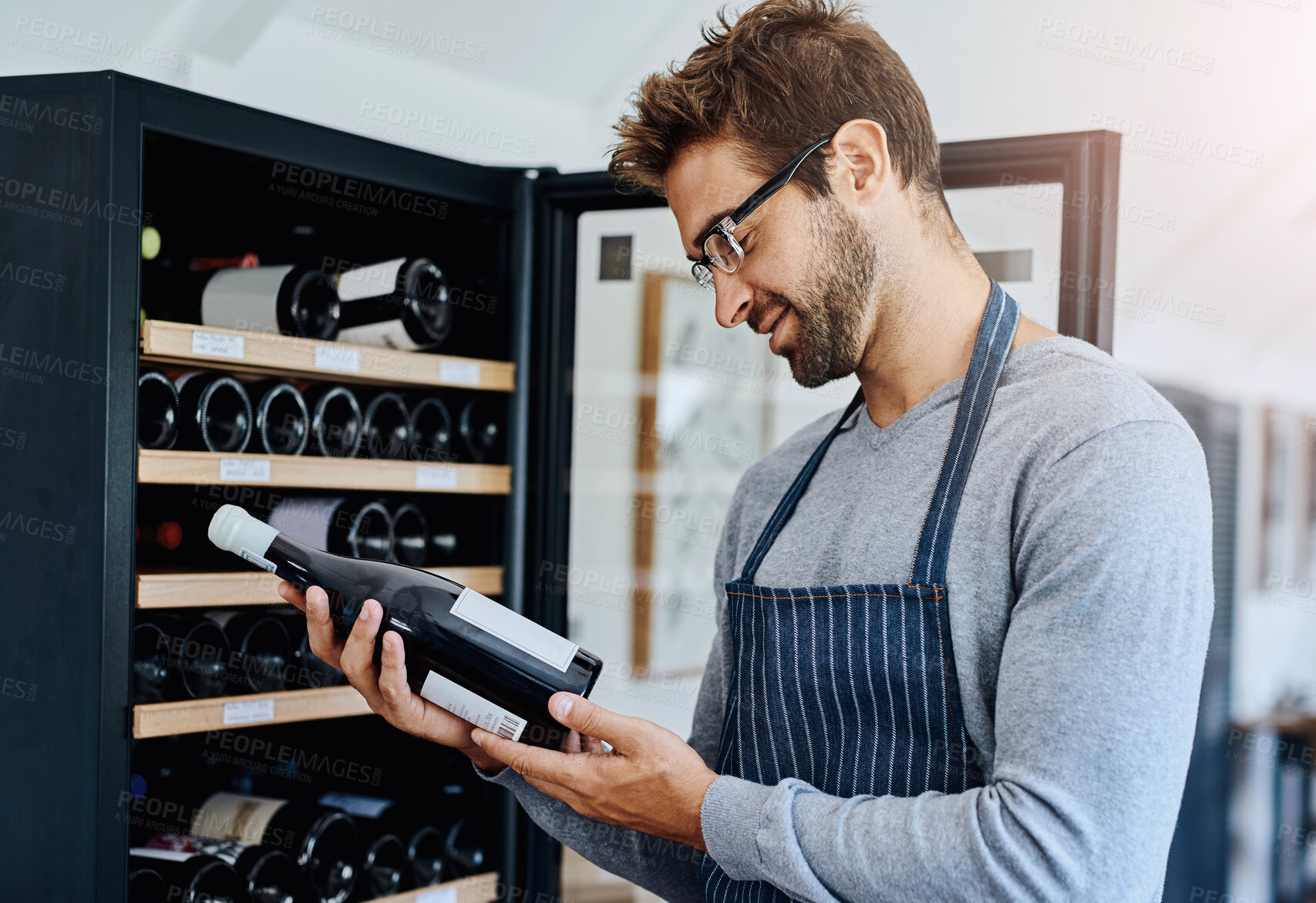 Buy stock photo Man, restaurant and waiter in wine cellar with smile for service, hospitality and professional. Employee, alcohol and happy or satisfied in winery with stock check for customer and luxury beverage