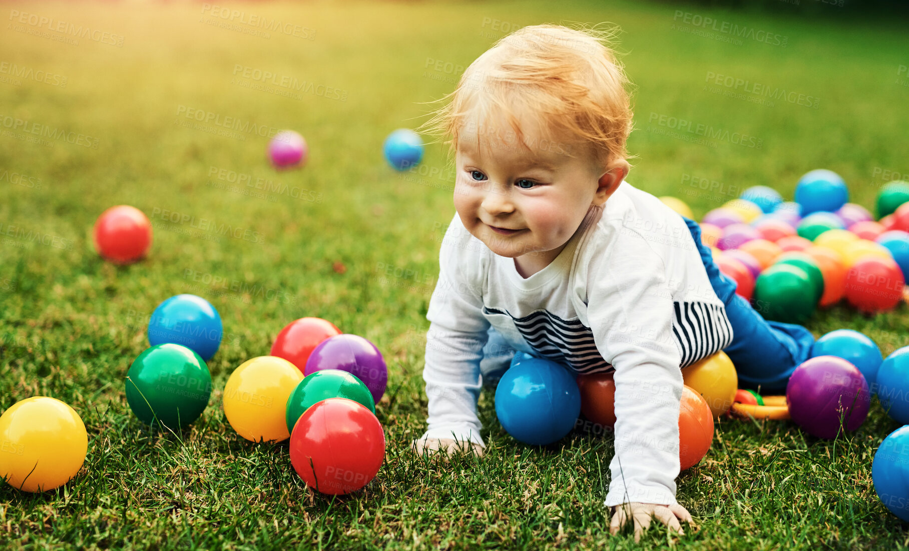 Buy stock photo Baby, grass and play with balls outdoor in park or backyard with motor skills and early childhood development. Happy child on floor crawling with colorful toys for holiday, fun and learning on lawn