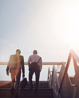 Buy stock photo Businessmen, chat and travel on stairs outdoor for walking to work with communication, flare and low angle. People, talk and commute together on steps in city for with back, networking and flare