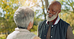 Love, happy and senior couple in park for walk, calm and talking in retirement in nature or forest. Partner, diverse and support or trust for man and female person, care and conversation together