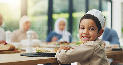 Buy stock photo Children, eid and portrait of muslim boy eating food with family in dining room of home for celebration. Dinner, happy or smile with face of Islamic child in apartment for culture, event or tradition