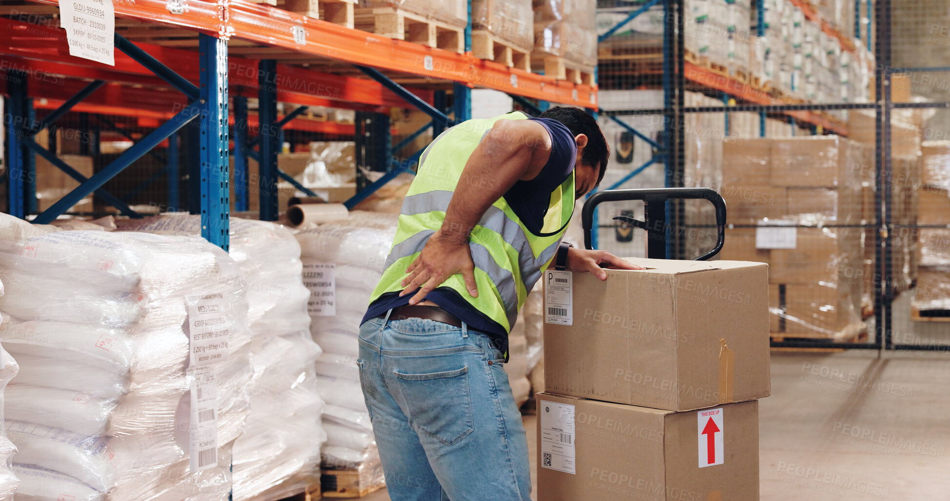 Buy stock photo Pallet truck, man and back pain in warehouse with transport, safety and storage for distribution or delivery. Freight operator, logistics and stock in cardboard for shipping, cargo and inventory