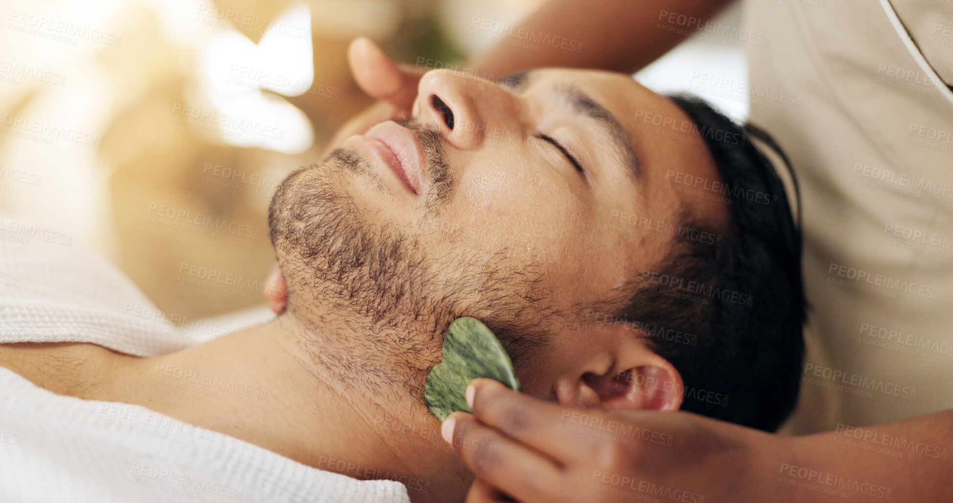 Buy stock photo Facial, beauty and man with gua sha treatment for massage, spa aesthetic and skincare benefits for circulation. Guy, dermatology and therapist hand with stone tool for wellness and lymphatic drainage