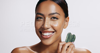 Buy stock photo Dermatology, portrait and woman with gua sha and smile for wellness, skincare and luxury spa. Face, cosmetics and lady glow with anti aging or jade stone treatment on white studio background