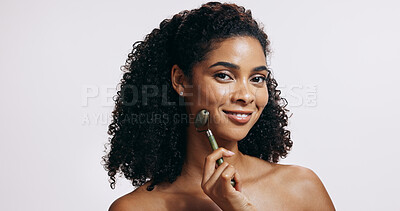 Buy stock photo Jade roller, portrait and woman with cosmetics, wellness and grooming routine on grey studio background. Face, person and model with tool, self care and massage with skincare, dermatology and beauty