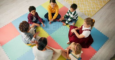 Buy stock photo Kindergarten, children and hands with game in circle for development, growth and activity. Teacher, high angle and playful student on mat in class for sensory education, learning and creative skill