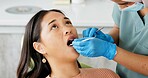 Asian woman, dentist and patient with clinic tools for cleaning mouth, oral or gum in dental care. Face of female person in relax with orthodontist for tooth whitening, hygiene or removing cavity