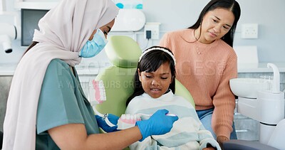 Buy stock photo Child, pediatric dentist or education of brushing teeth in surgery or family friendly demonstration of tooth hygiene. Girl, parent or orthodontist with dental model to brush or lesson on mouth care