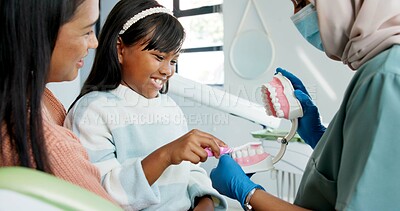 Buy stock photo Girl, dentist or education on brushing teeth with toothbrush in practice or child friendly dentistry of tooth hygiene. Orthodontist, mother or kid by dental model or clean mouth in interactive lesson