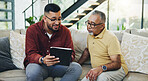 Tablet, teaching and man with senior father on sofa helping with communication, internet or email. Happy, bonding and elderly male person learning digital technology with son in living room at home.