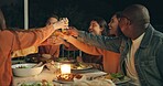 Friends, group toast and dinner on patio, night and conversation with food, new years eve and party. Women, man and outdoor at table with juice, memory or celebration with cheers, diversity or goals