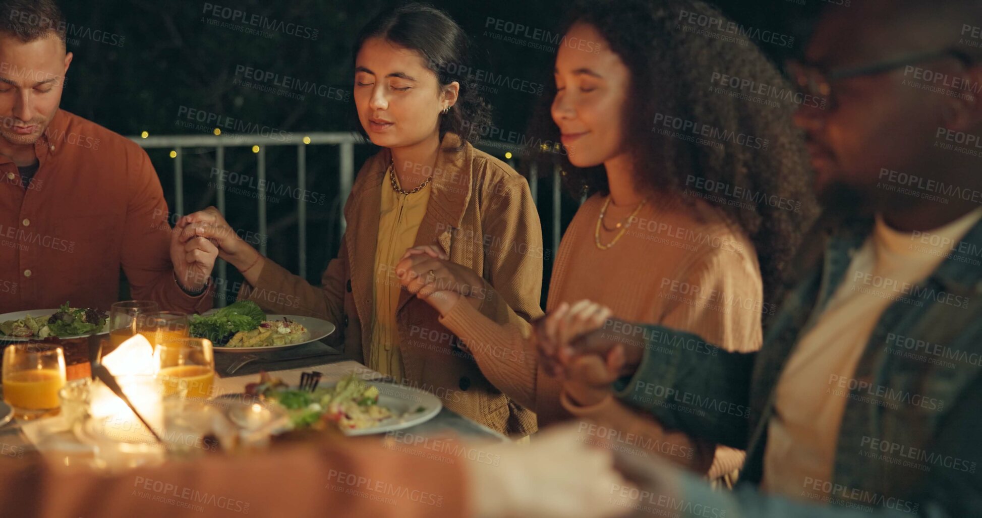 Buy stock photo Friends, holding hands and prayer, food and worship together, gratitude and thanks to God at dinner party. Men, women and diversity with nutrition and religion, celebration and social event at night