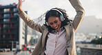 Happy woman, headphones and dancing in city with music, online or streaming in outdoor for communication. Career person, technology and cheerful for celebration, connection or motivation in England