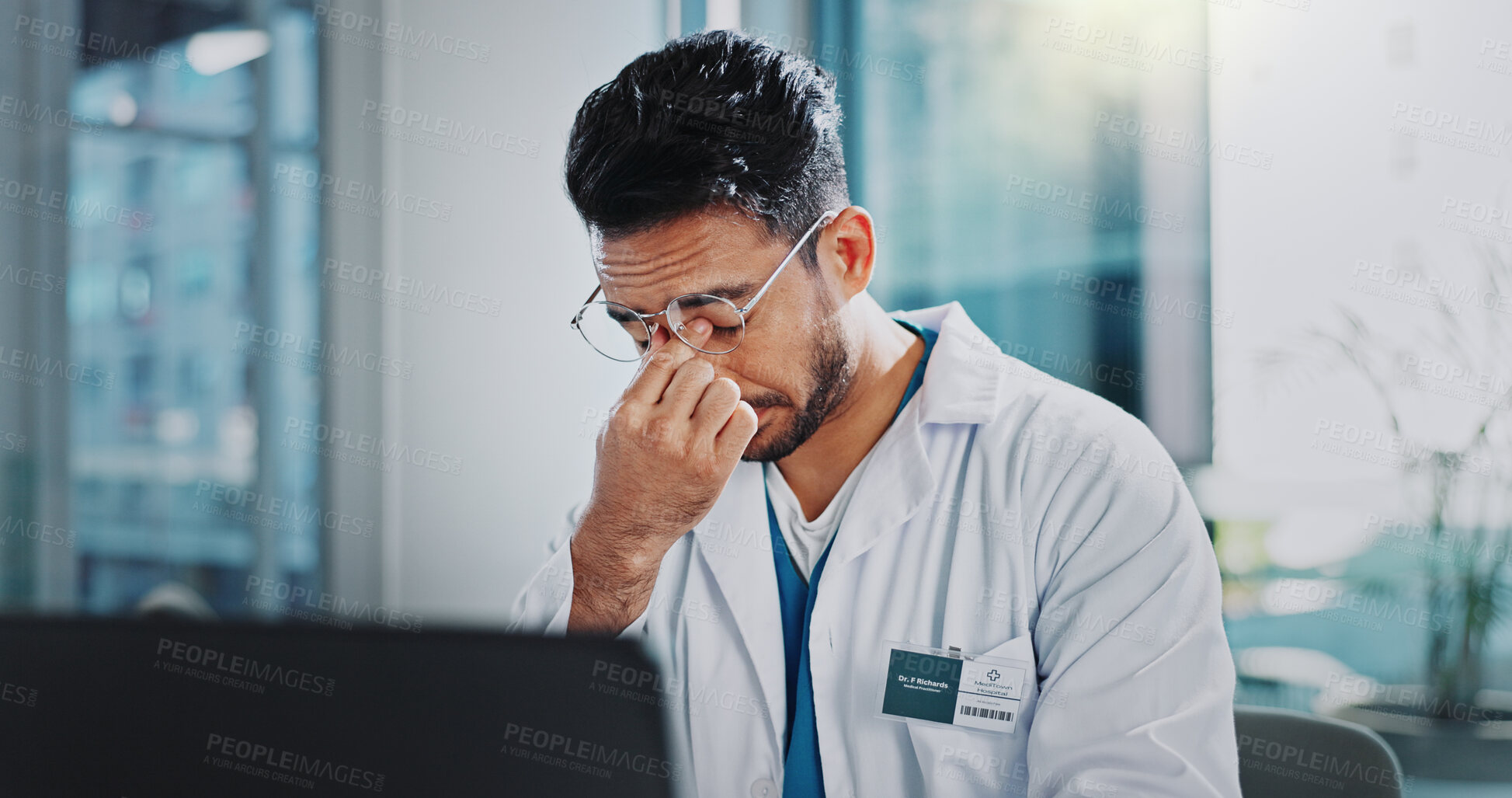 Buy stock photo Doctor, man and tired with headache by laptop, anxiety and frustrated in modern office at hospital. Person, pain and stress with migraine, fatigue and burnout with computer for telehealth services