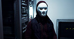 Server room, hacker and person with mask, night and scam of cybersecurity, phishing and cyber crime. Mysterious, thief and cover on face, fraud and spy with system, stealing and cables for hacking