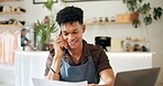 Cafe, phone call and man with laptop, reading and smile for application of loan and small business. Happy, entrepreneur and person with apron, mobile and communication for restaurant and startup