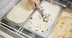 Hands, ice cream and scoop at shop for service of frozen food, dessert and sweets in top view at cafe. Gelato, seller and person on metal tray closeup for dairy, sugar or vanilla treat at store above