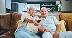Senior couple, sofa and watching tv with remote for movie, online subscription or show in living room at home. Elderly man and woman in relax for media entertainment or series in retirement at house