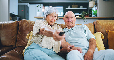 Buy stock photo Senior couple, sofa and watching tv with remote for movie, online subscription or show in living room at home. Elderly man and woman in relax for media entertainment or series in retirement at house