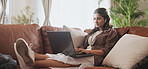 Student, laptop and woman on sofa with earphones for education, university project or assignment in living room. Online, typing and female person with tech for revision, exam notes or streaming music