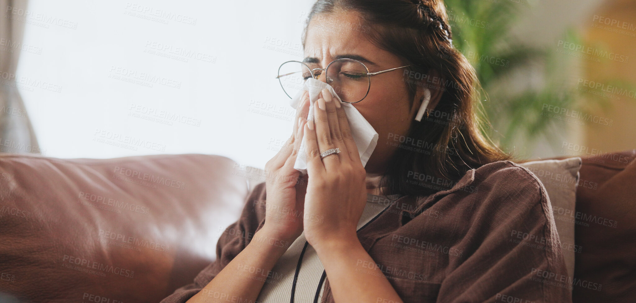 Buy stock photo Sick, tissue and woman on sofa with in home with earbuds listening to music, podcast or radio. Illness, living room and female person blow nose with flu, cold or allergies streaming playlist at house