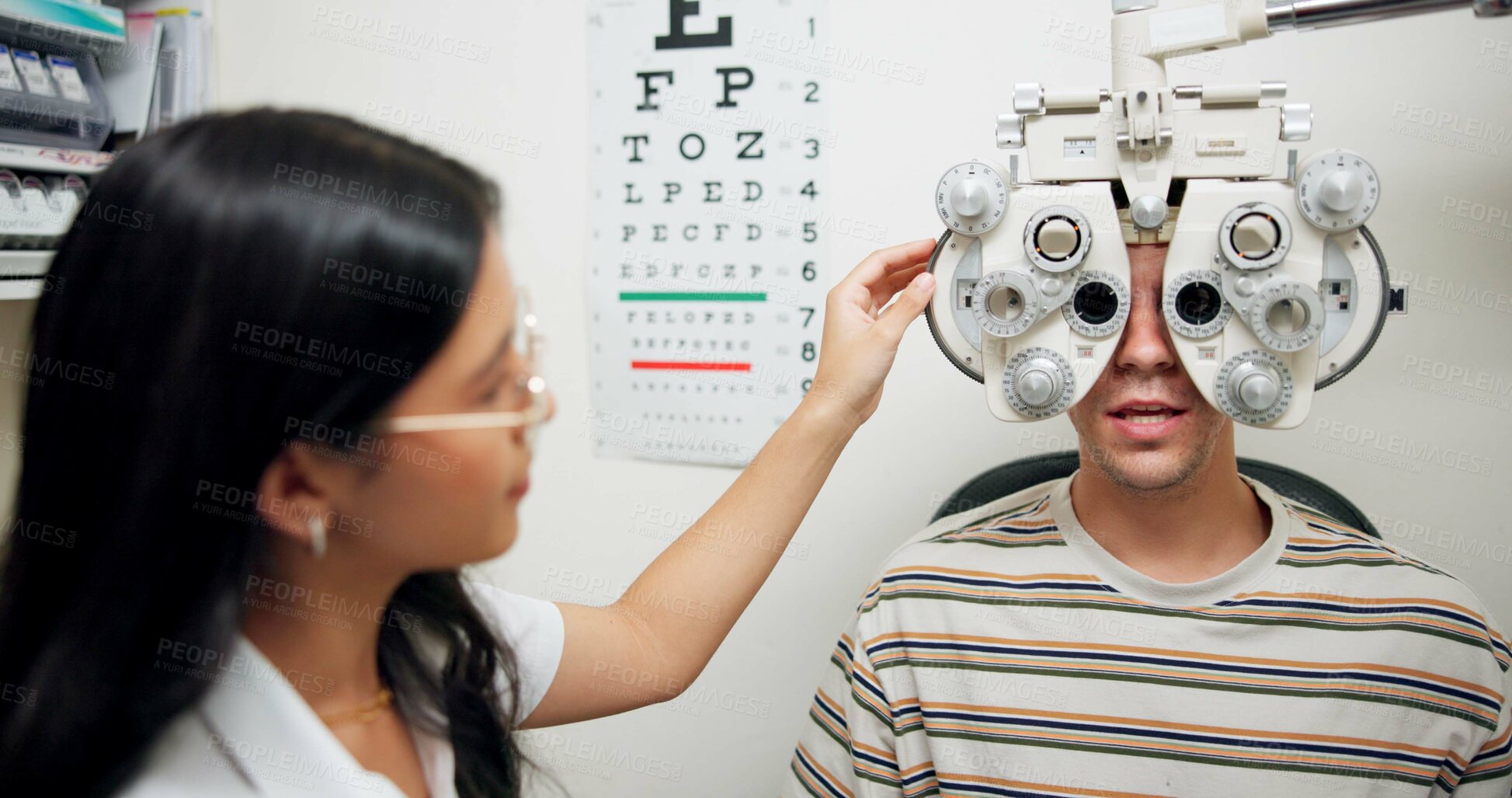 Buy stock photo Doctor, ophthalmologist and man on phoropter for eye care, consultation and healthcare exam in clinic. Optometry, test and patient on lens machine for vision check, wellness and eyesight correction