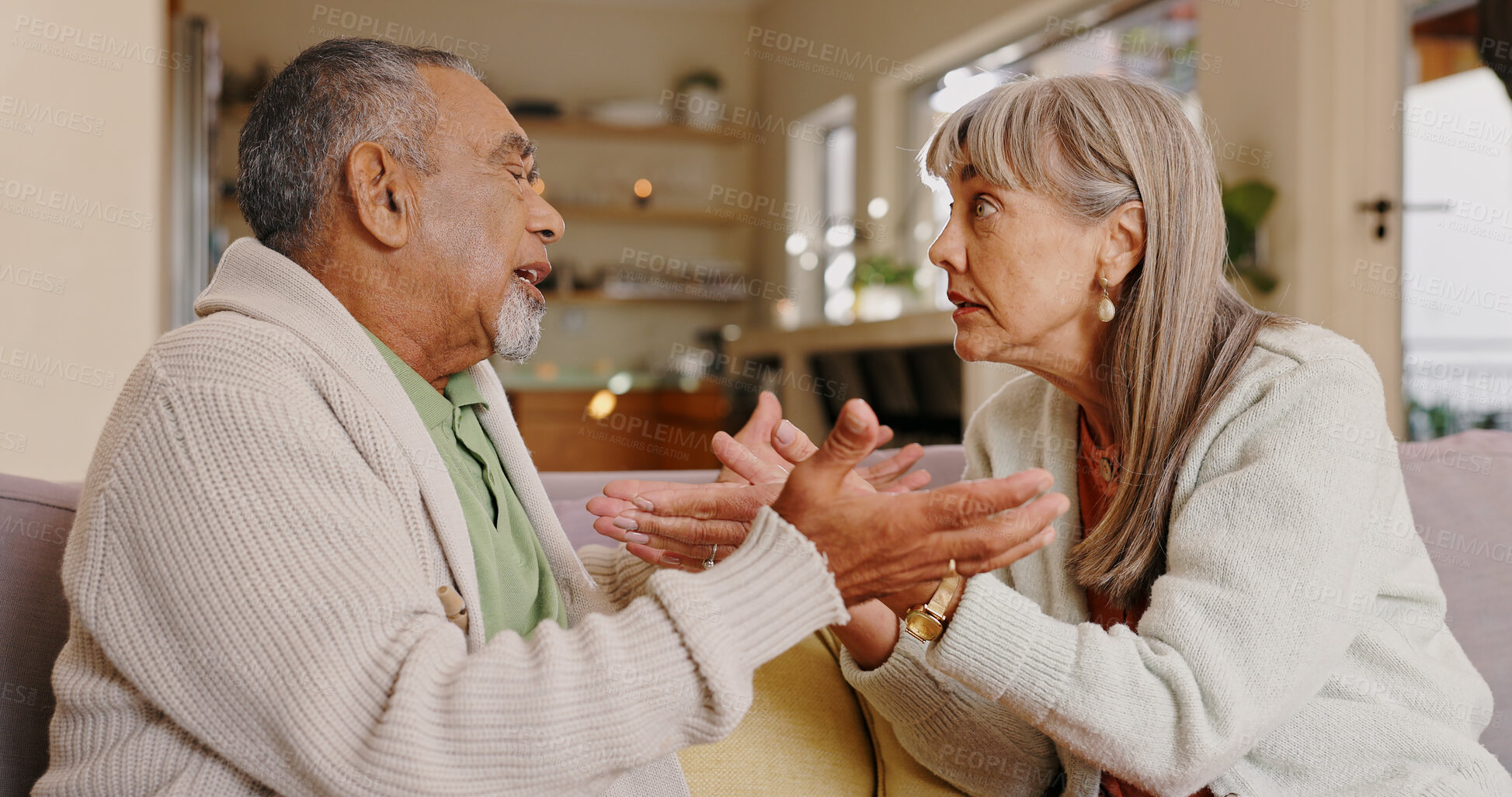 Buy stock photo Elderly couple, talking and arguing in lounge, couch and discussion in retirement, weekend and upset in house. Angry, old man and woman in living room, fighting and people in apartment and marriage