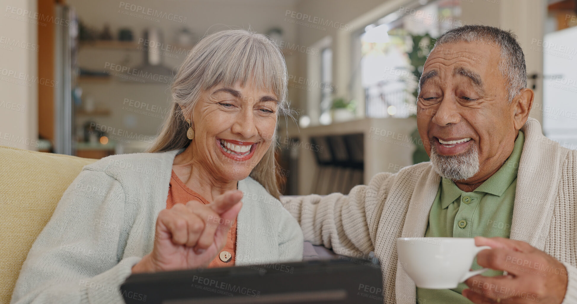 Buy stock photo Tablet, laughing and senior couple on couch with retirement meme and streaming comedy film in home. Interracial marriage, elderly man and woman with tech on sofa for funny gif and reading silly story