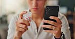 Person, hands and pills with phone for medication, dosage or side effects and symptoms at home. Closeup of patient checking or reading tablets on pharmaceuticals, mobile smartphone or prescription