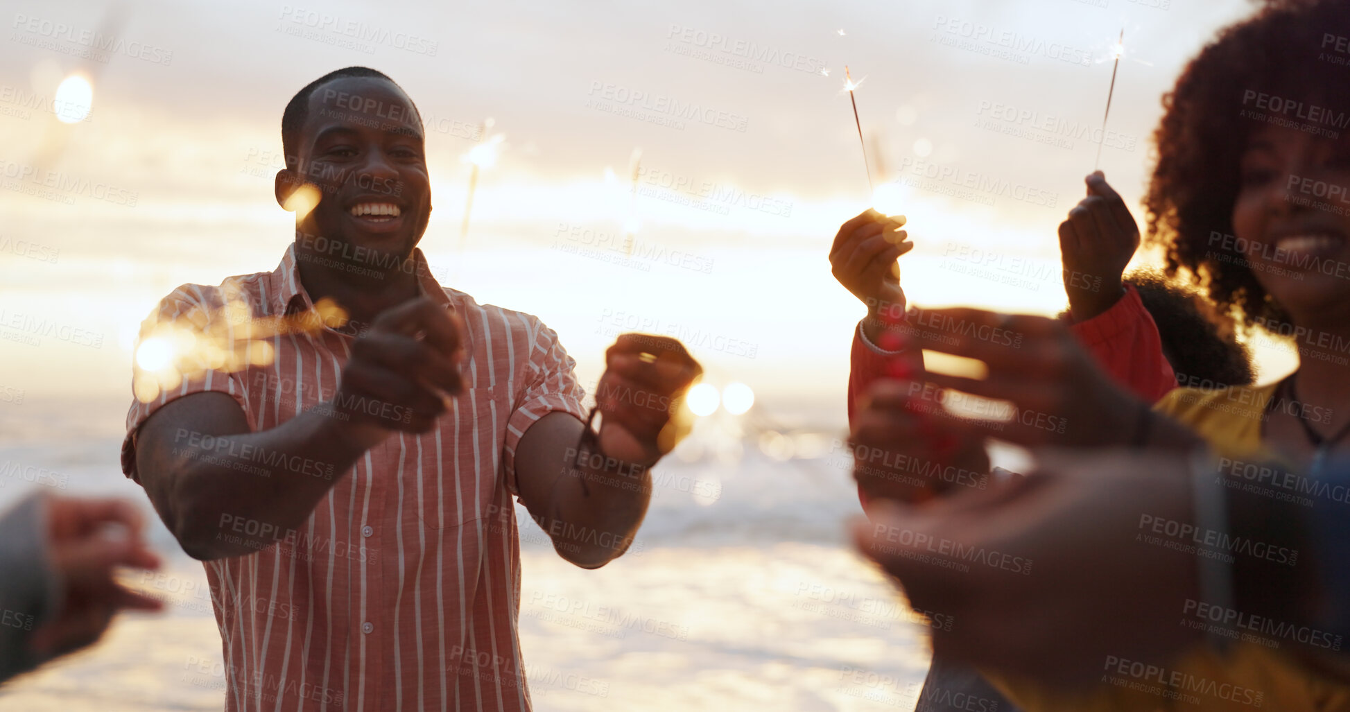 Buy stock photo Beach, sparkler and group of people at party with happiness, celebration with friends on vacation. Crowd, smile and fireworks on island holiday in Bali for travel, together for festival at sunset