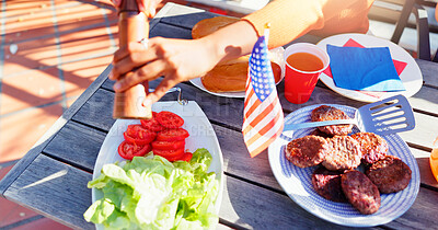 Buy stock photo Hamburger, American flag and salad on plate outdoor at reunion lunch for national independence day. Hands, vegetables and patty on bun by wooden table for United states holiday event in backyard.