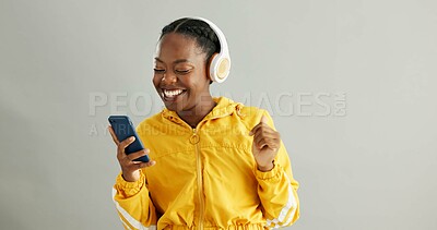 Buy stock photo African woman, phone and headphones in studio with scroll for song, search or happy by white background. Gen z girl, smartphone and listening to music, streaming or subscription on mobile application