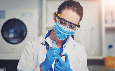 Buy stock photo Closeup of an unrecognizable female scientist wearing a protective face mask and holding up a vile of blood inside of a laboratory