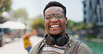 Portrait, student and black man in city, happiness and break with adventure, headphones and education. Face, African person and college with guy, headset and walking with smile, travel and knowledge