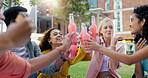 Students, cheers and park with happy friends, diversity and picnic with smile in summer on campus. University, toast and group with bonding and drink on lawn of academy and college with Gen Z people