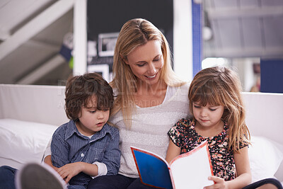 Buy stock photo Reading, mom and children on sofa with book for bonding, teaching and learning together in home. Woman, son and daughter relax on couch for bedtime storytelling, smile and happy family in living room