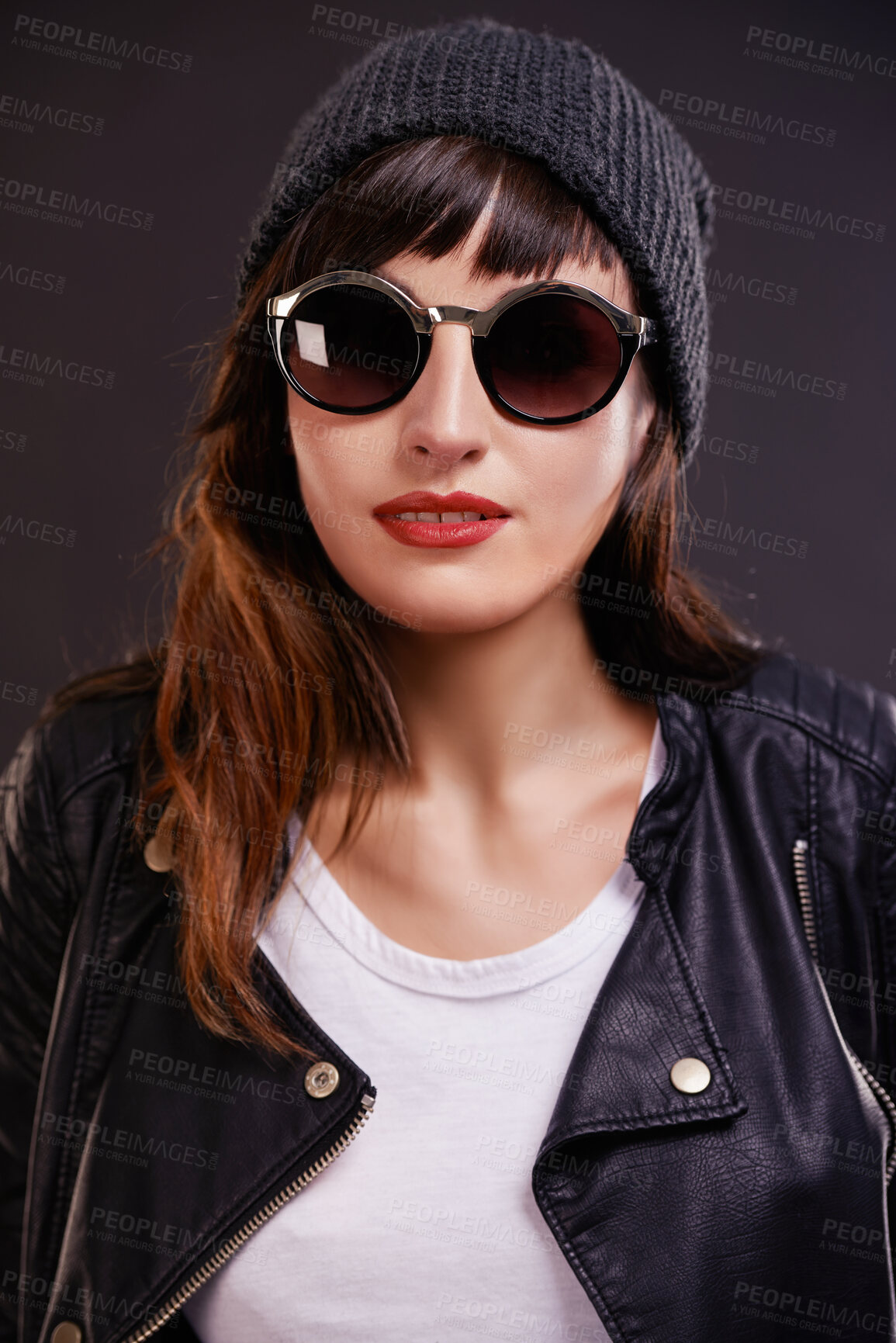 Buy stock photo Confident, woman and punk fashion in studio for trendy rocker style with sunglasses. Bold, female person and leather clothes for creative skin tattoo, art decoration and grunge by dark background
