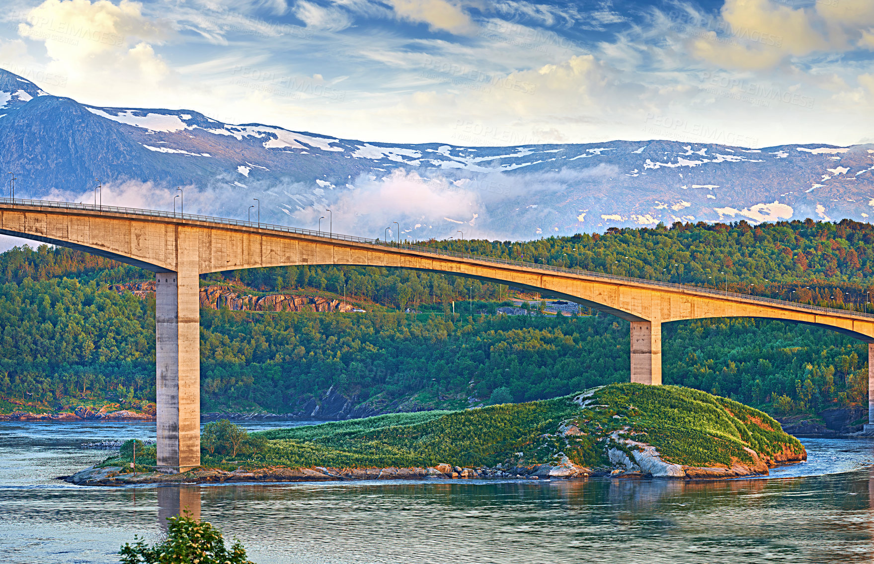 Buy stock photo Bridge, road and outdoor with snow on mountains, nature and trees in forest by water. Landscape, woods and hill with highway, infrastructure and transportation in environment with summer in Norway