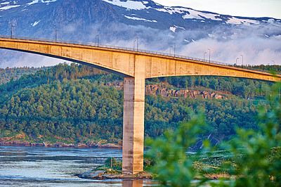 Buy stock photo Bridge, road and water with snow on mountains, nature and trees for transport system in forest. Landscape, woods and hill with highway, infrastructure and travel in environment by river in Norway