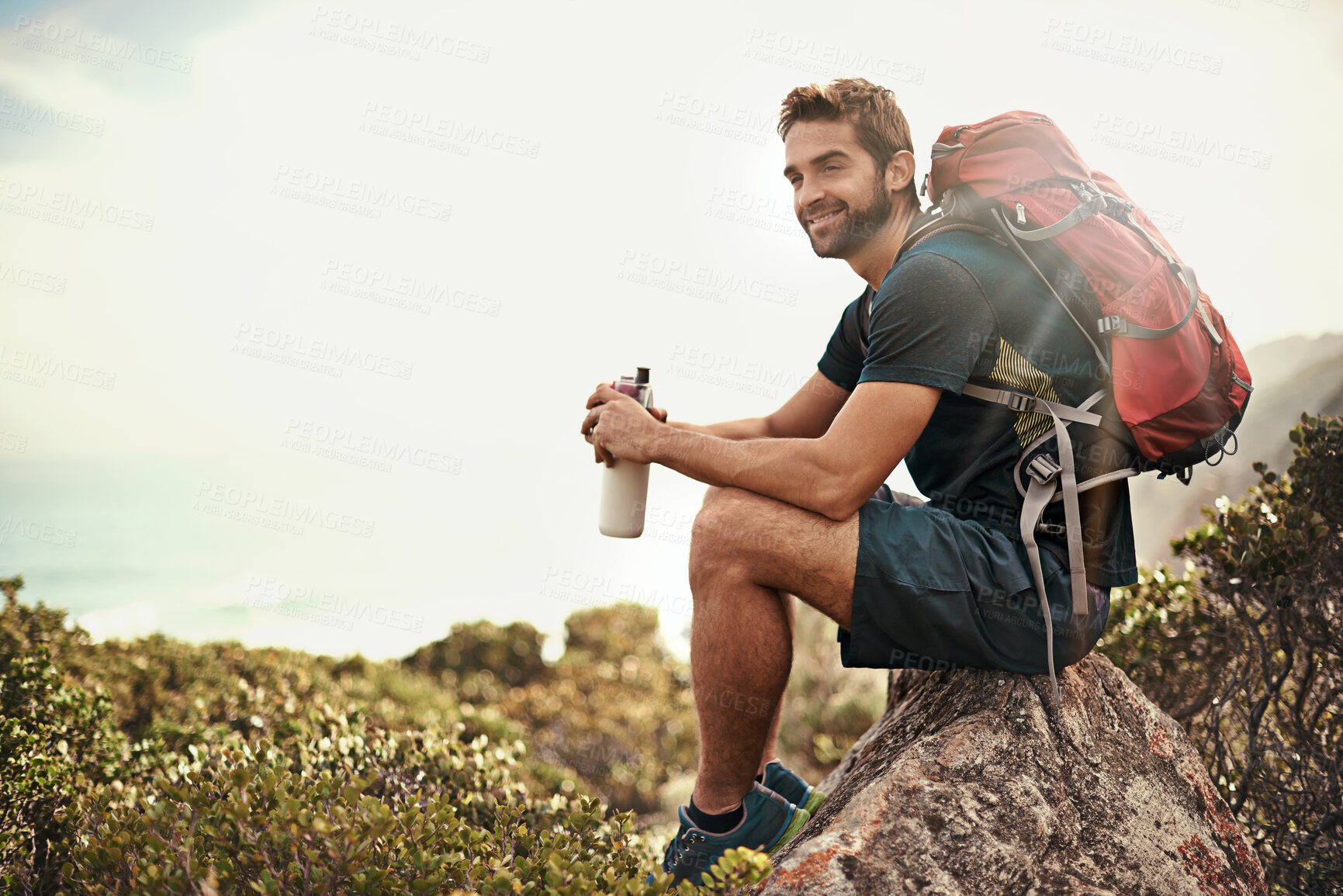 Buy stock photo Shot of a young man taking a water break while out hiking