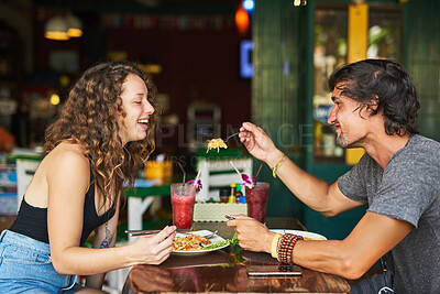 Buy stock photo Restaurant, food and couple for feeding on date, hangout and people chilling together for bonding with meal. Relationship, boyfriend and girlfriend with beverage, hungry and romantic lunch in Germany