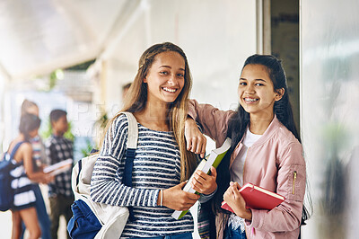 Buy stock photo Portrait of two happy schoolgirls standing together in the hallway outside their classroom