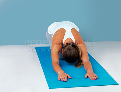 Buy stock photo Woman, yoga mat and child pose for stretching in studio, floor and breathing by blue background. Person, wellness and zen with balance, circulation and training with mindfulness with self care