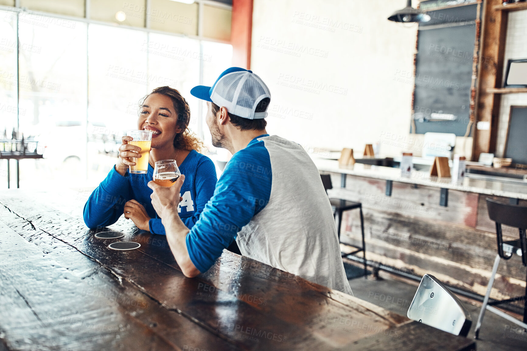 Buy stock photo Sports, drinking or couple in pub with alcohol, smile or social celebration of competition together. Cheers, soccer game or people in bar for watch party, beer drinks or fans at diner for happy hour