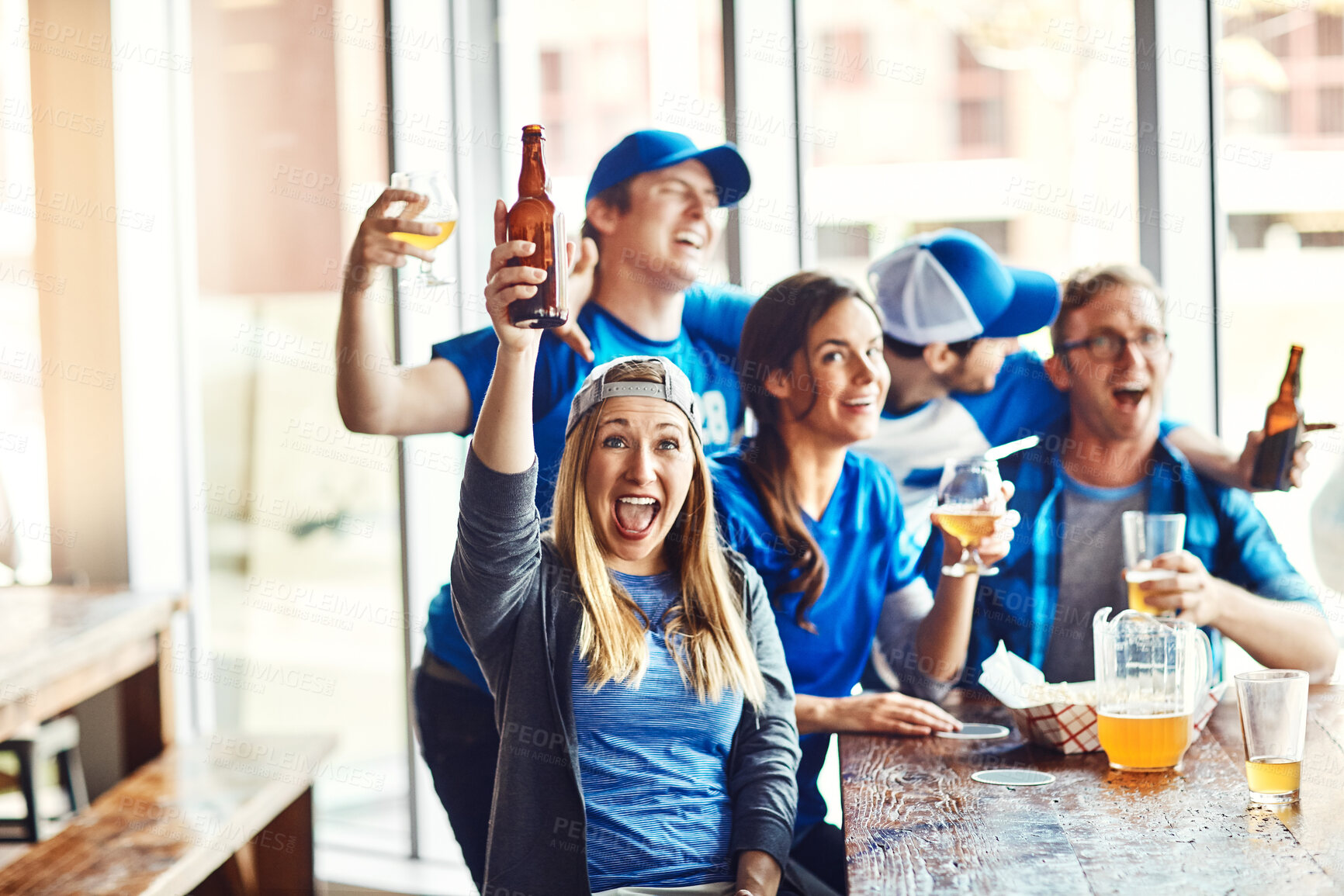 Buy stock photo Group, supporters and winning team at pub, cheering for victory in sports on television with celebrating goal. People, fans and beer for soccer challenge or match as friends with loyalty in world cup