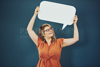 Buy stock photo Speech bubble, poster and woman in studio for news, announcement and feedback. Mockup space, social media and happy person with sign for information, advertising and promotion on blue background