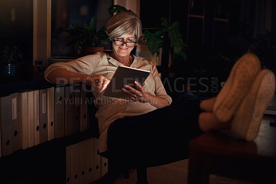 Buy stock photo Reading, tablet and mature woman on sofa with relax for notification, web blog or comfortable in living room. Online, night and person with glasses for information, email or news article in home