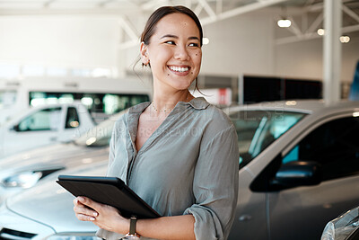 Buy stock photo Shot of a woman using her digital tablet in a car dealership