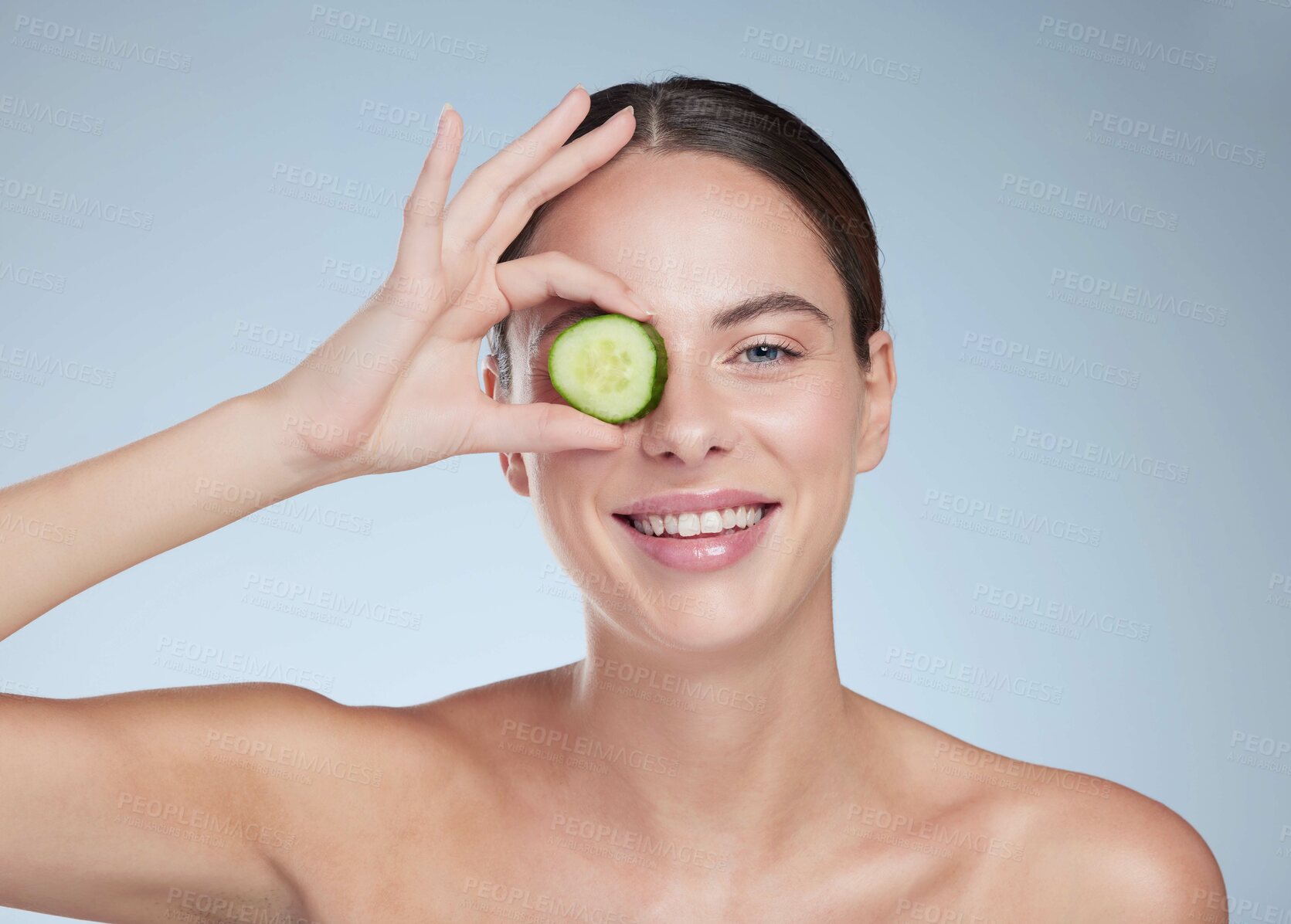 Buy stock photo Portrait smile, woman and cucumber for skincare with vegan diet, healthy nutrition and beauty in studio. Happy model,  dermatology and fruit for clean eating, facial glow and detox by gray background