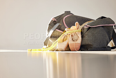 Buy stock photo Closeup, isolated and ballet slippers on floor with exercise bag, measuring tape and lose weight for health. Zoom, dance and pointe shoes on ground with workout duffle, training progress and goals